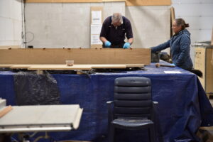 Het aanbrengen van lijm en deuvels in de 1e plank